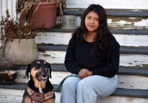 Mujer sentada en escaleras con perro