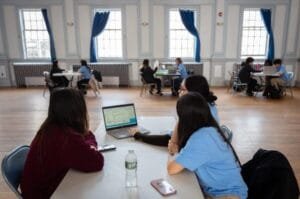 Estudiantes trabajando con portátiles en aula luminosa